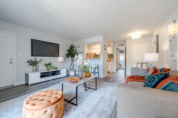 Phoenix apartment for rent - A living room with a grey couch and a white entertainment center.