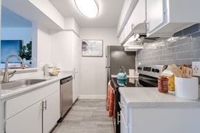 Phoenix apartment for rent - A modern kitchen with white cabinets and a grey countertop.