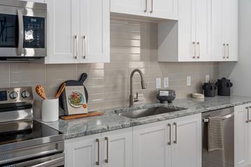 Gilbert apartment for rent - A kitchen with white cabinets and a granite countertop.