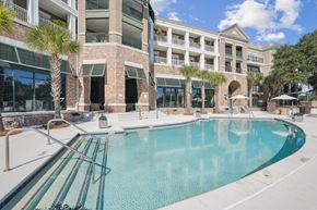 Charleston apartment for rent - A large swimming pool in front of a multi-story building.