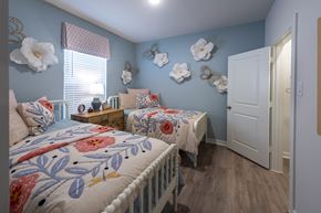 Cypress apartment for rent - A bedroom with two beds and a white door.