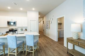 Cypress apartment for rent - A kitchen with a white counter top and blue chairs.