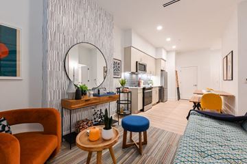 Washington apartment for rent - A living room with a red chair and a blue stool.
