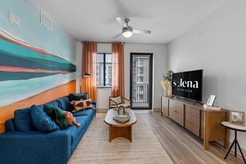 Miramar apartment for rent - A living room with a blue sofa and a television displaying the word "Siena".