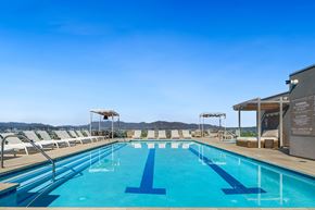 Los Angeles apartment for rent - a swimming pool on the rooftop of a hotel with mountains in the background