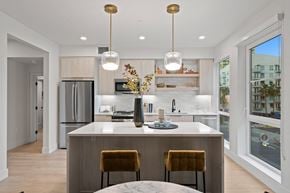 Long Beach apartment for rent - an open kitchen and dining area with a large island and two yellow chairs