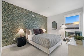 Long Beach apartment for rent - a bedroom with a bed and a wall with a green wallpaper