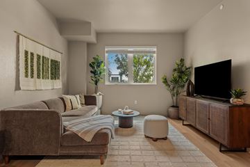 Inglewood apartment for rent - A living room with a brown couch, a white rug, and a television on a wooden cabinet.
