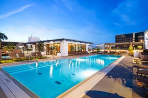 Irvine apartment for rent - A large swimming pool in the foreground with a building in the background.