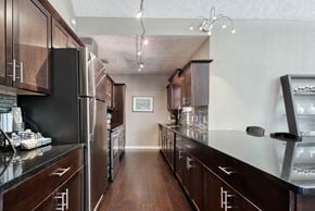 San Antonio apartment for rent - a kitchen with dark wood cabinets and granite countertops