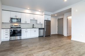 Seattle apartment for rent - A kitchen with white cabinets and a wooden floor.