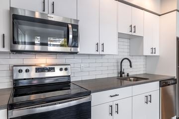 Seattle apartment for rent - A modern kitchen with a stainless steel oven and white cabinets.