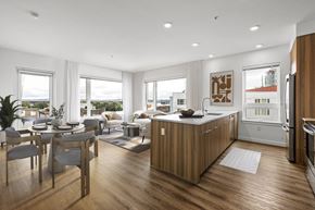 Seattle apartment for rent - A modern kitchen with wooden cabinets and a dining table with chairs.