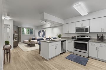 Bellevue apartment for rent - A modern kitchen with white cabinets and a wooden floor.