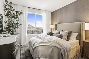 San Diego apartment for rent - A well-lit bedroom with a large bed and a view of the city.