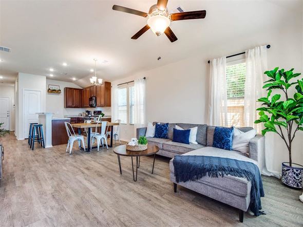 Conroe apartment for rent - a living room with a couch and a ceiling fan at The Village at Caney Mills, Texas, 77303