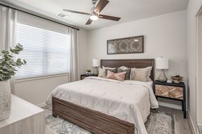 Houston apartment for rent - A bedroom with a large bed and a ceiling fan.