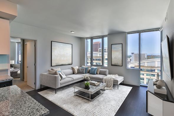 Bellevue apartment for rent - Modern living room at Soma Towers Bellevue Washington apartments with a grey sofa and glass coffee table.