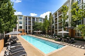 Brentwood apartment for rent - A swimming pool surrounded by lounge chairs and umbrellas in front of apartment buildings.