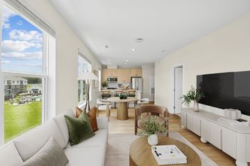 Londonderry apartment for rent - A modern living room with a white couch and a large window overlooking a green lawn.