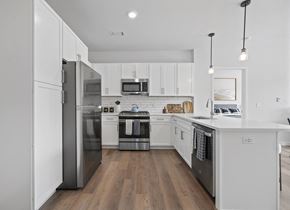 Wilton apartment for rent - a large kitchen with white cabinets and stainless steel appliances
