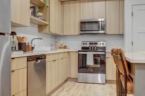 Lehi apartment for rent - a kitchen with wooden cabinets and stainless steel appliances