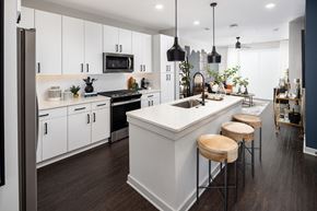 Atlanta apartment for rent - a kitchen with white cabinets and a large island with three stools