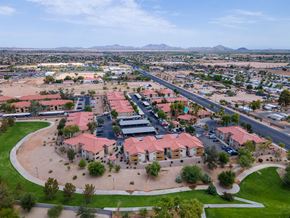 Casa Grande apartment for rent - A large building with a red roof is surrounded by a parking lot and other buildings.