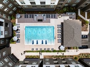 Dalton apartment for rent - A swimming pool surrounded by lounge chairs and umbrellas in a courtyard.