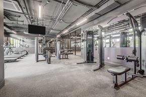 Salt Lake City apartment for rent - a gym with weights and machines and a tv