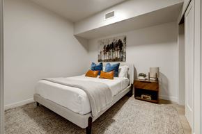 Salt Lake City apartment for rent - bedroom with white walls and a white bed with orange and blue pillows