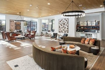 Nashville apartment for rent - A modern living room with a curved sofa and a chandelier.