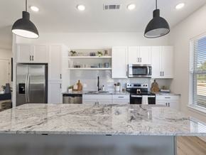 Leander apartment for rent - a kitchen with white cabinets and a marble counter top