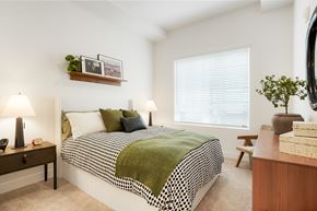 Salt Lake City apartment for rent - A bedroom with a bed, nightstand, and a window with blinds.