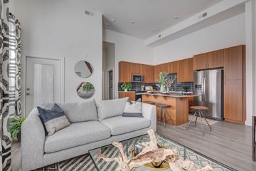 Clearfield apartment for rent - A modern living room with a grey sofa and a wooden kitchen area.