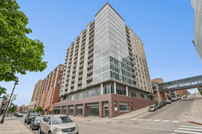 Duluth apartment for rent - A tall building with a glass facade stands in the middle of a city street.