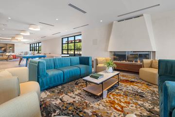 Scottsdale apartment for rent - A modern living room with a blue sofa and a patterned rug.