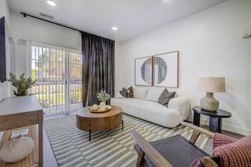 West Valley apartment for rent - A living room with a white couch, a coffee table, and a painting on the wall.