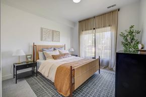 West Valley apartment for rent - A bedroom with a large bed and a lamp on a nightstand.