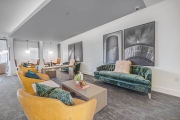 West Valley apartment for rent - A living room with a green velvet couch and yellow chairs.