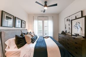 Fort Worth apartment for rent - a bedroom with a large bed and a ceiling fan