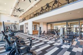 Fort Worth apartment for rent - a gym with cardio machines and weights on a checkered floor