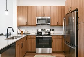 Fort Worth apartment for rent - a kitchen with stainless steel appliances and wooden cabinets