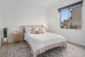Mesa apartment for rent - A bedroom with a large bed and a window overlooking a building.