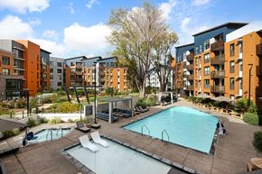Mountain View apartment for rent - A large swimming pool surrounded by a wooden deck and lounge chairs.