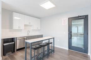 West New York apartment for rent - A resident kitchen with a white counter top and a black trash can.