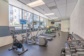 Portland apartment for rent - a large fitness room with cardio equipment and a large window