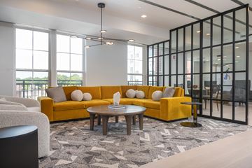 Ronkonkoma apartment for rent - A modern living room with a yellow sofa and a patterned rug.
