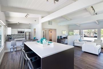 San Jose apartment for rent - A modern kitchen with a white island and a dining table with chairs.