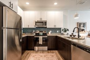 Arvada apartment for rent - A modern kitchen with a stainless steel refrigerator and dark wood cabinets.
